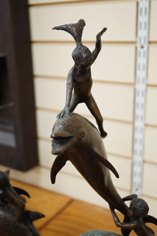 A pair of bronze leaping dolphin and amorini sculptures, unsigned, 54cm high. Condition - fair